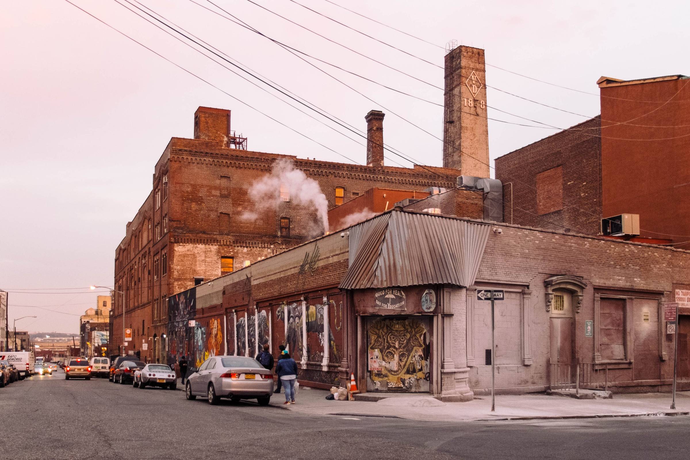 A brick industrial works on a quiet street under flat daylight.